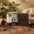 Vrikshanic Coffee & Charcoal Soap bar with box on wooden table, surrounded by coffee beans and charcoal.